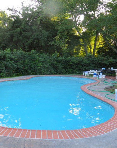 A pool with chairs and tables in the middle of it