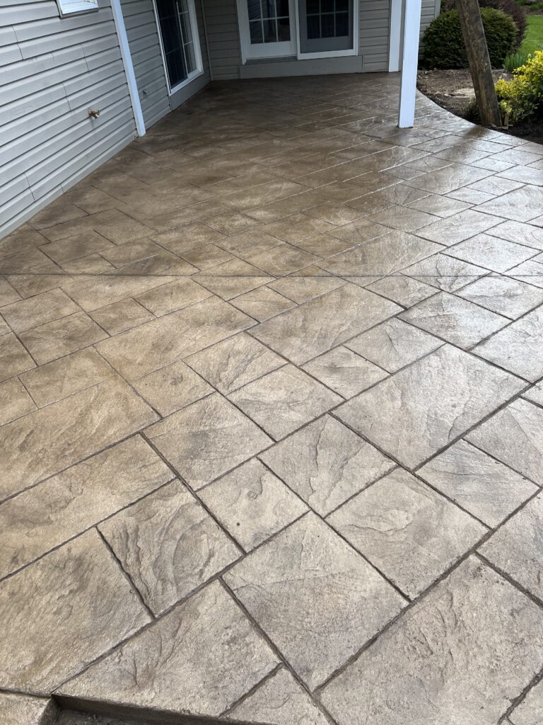 A patio with a stone pattern and a brick floor.