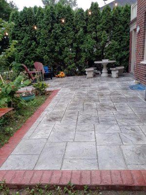 20200803_195806 A patio with brick border and concrete slab.