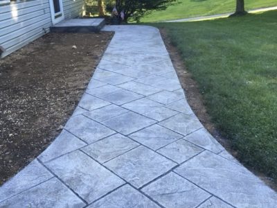 A walkway with a cement pattern leading to the house.
