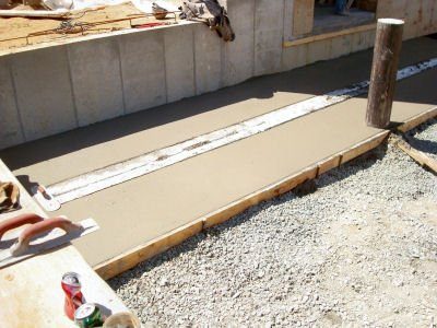 A cement slab being poured for the floor of a house.