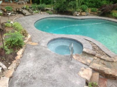A pool with a hot tub in the middle of it