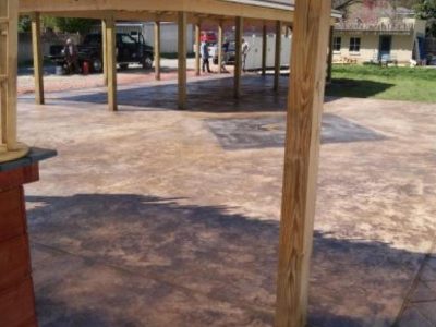 A patio with an umbrella and a wooden structure.