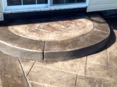 A patio with steps leading to the door.