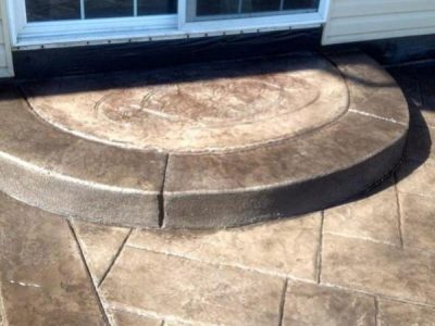 A patio with steps leading to the door.