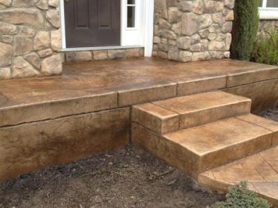 A front porch with steps and stone walls.